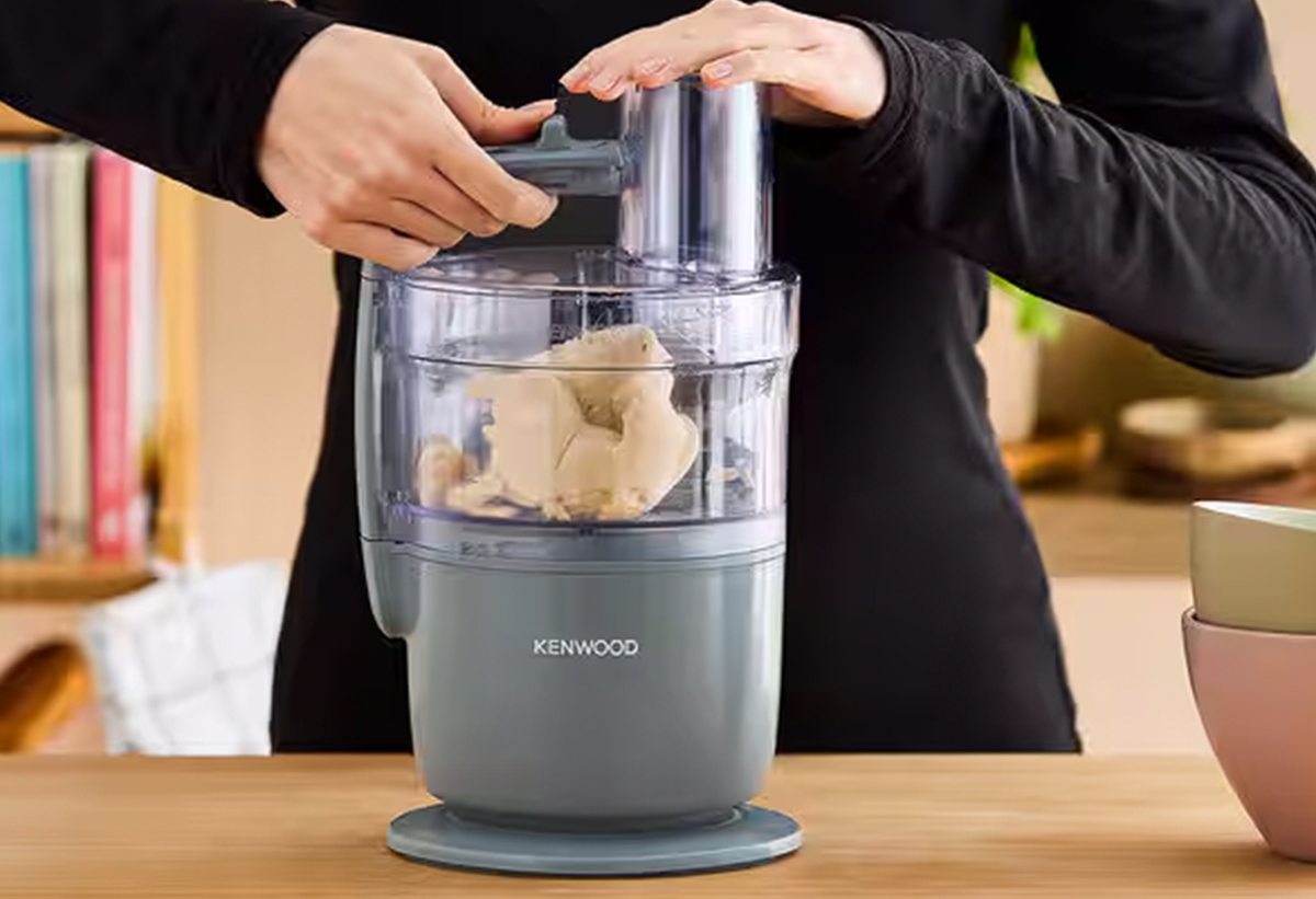 Παρουσιάζει το πολυμίξερ πάνω σε ένα πάγκο να το χρησιμοποιεί ένας άνθρωπος